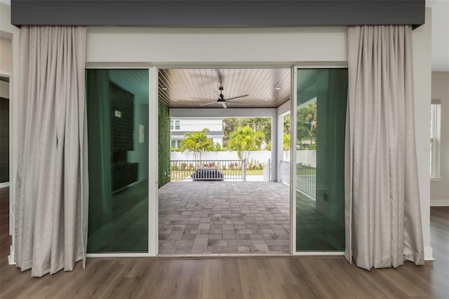 doorway to outside featuring wood-type flooring and ceiling fan