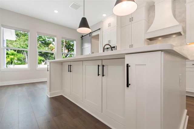 kitchen with dark hardwood / wood-style floors, hanging light fixtures, custom exhaust hood, and white cabinets