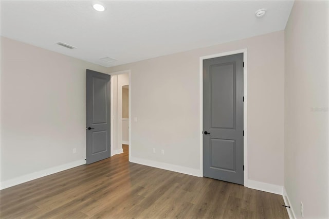 spare room featuring wood-type flooring