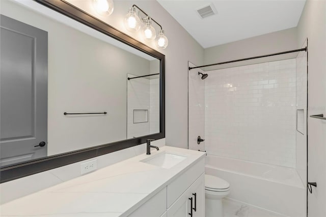 full bathroom with tiled shower / bath, vanity, and toilet