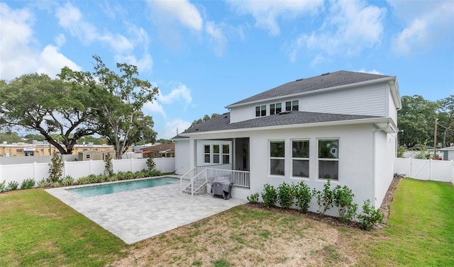 rear view of property featuring a patio and a lawn