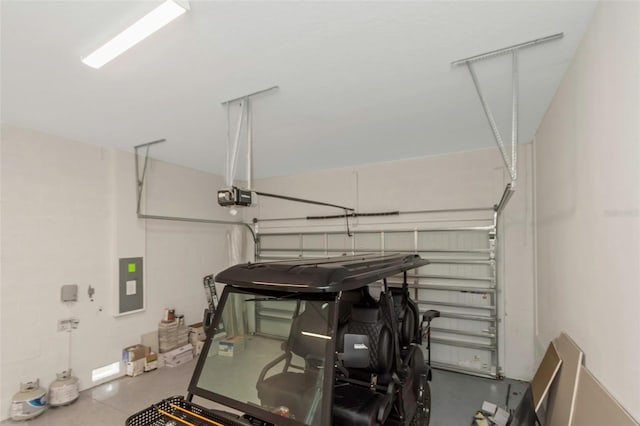 garage with a garage door opener and electric panel