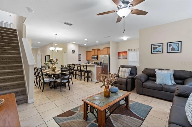 tiled living room featuring ceiling fan with notable chandelier