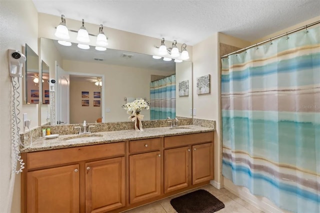 bathroom with tile patterned floors, shower / bath combo, vanity, and a textured ceiling