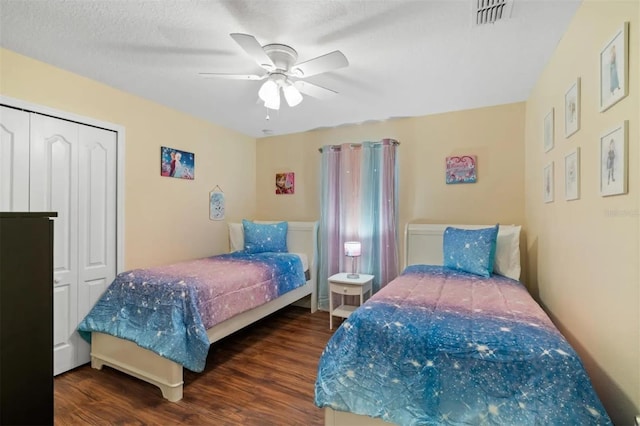 bedroom featuring ceiling fan, dark hardwood / wood-style flooring, and a closet