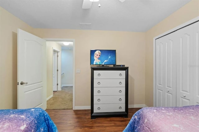 bedroom with dark wood-type flooring, ceiling fan, and a closet