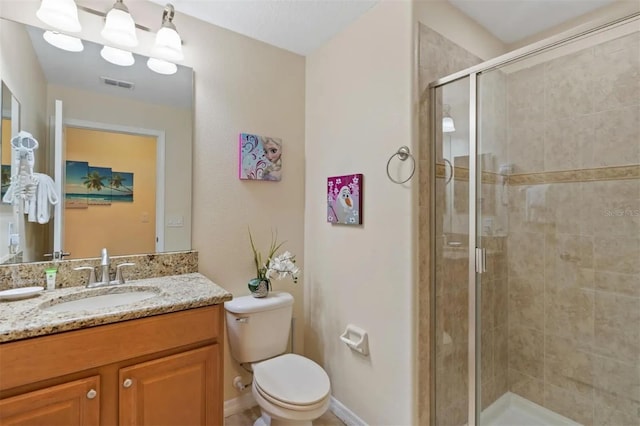 bathroom featuring vanity, toilet, and a shower with shower door