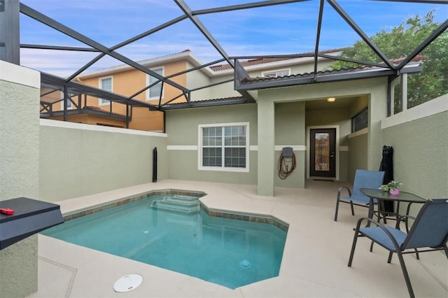 view of swimming pool featuring glass enclosure and a patio area