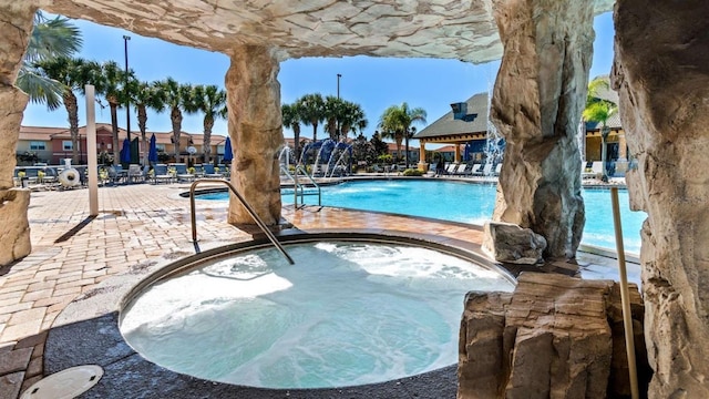 view of swimming pool with a hot tub and a patio