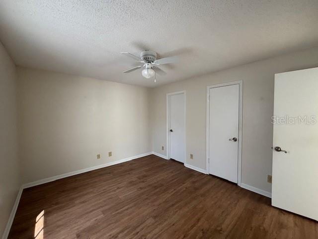 unfurnished bedroom with ceiling fan, dark hardwood / wood-style floors, and a textured ceiling