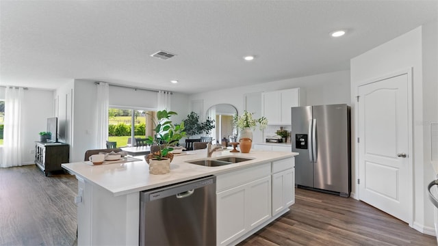 kitchen featuring sink, white cabinetry, a center island with sink, appliances with stainless steel finishes, and dark hardwood / wood-style flooring