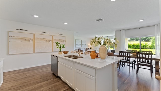 kitchen featuring sink, white cabinetry, a center island with sink, dishwasher, and hardwood / wood-style floors