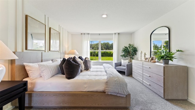 bedroom featuring light colored carpet and multiple windows