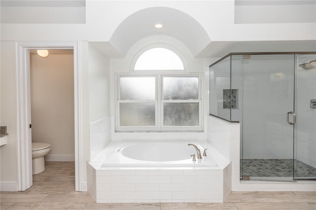 bathroom featuring toilet and independent shower and bath