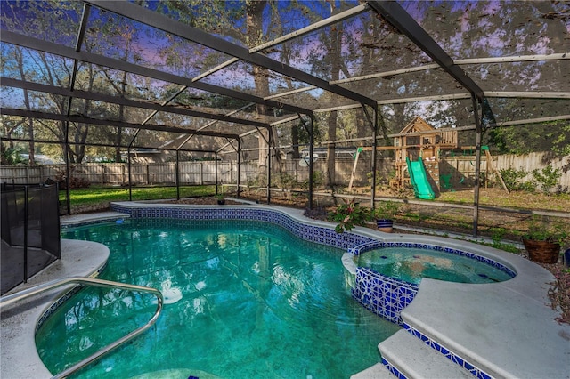 view of pool with a playground, an in ground hot tub, and glass enclosure