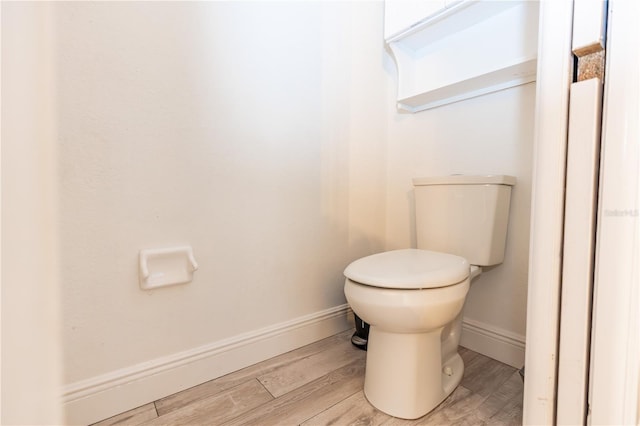 bathroom featuring wood-type flooring and toilet