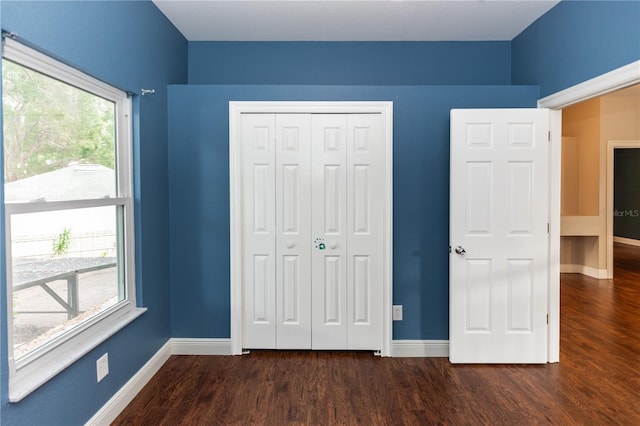 unfurnished bedroom featuring dark hardwood / wood-style flooring and a closet