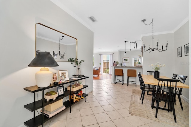 dining space featuring crown molding, light tile patterned floors, track lighting, and a chandelier