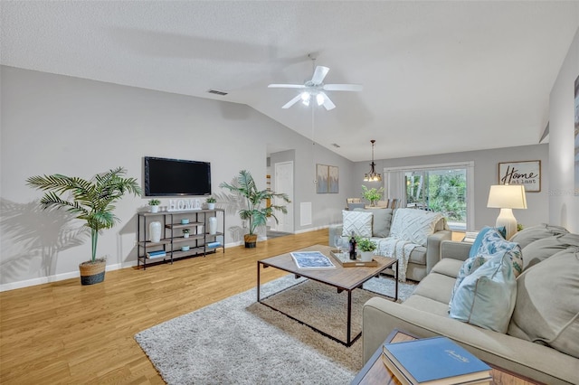 living room with wood-type flooring, lofted ceiling, a textured ceiling, and ceiling fan