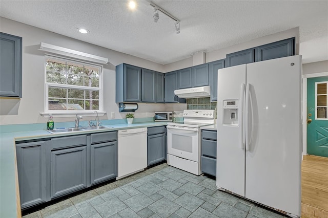 kitchen with sink, a textured ceiling, and white appliances