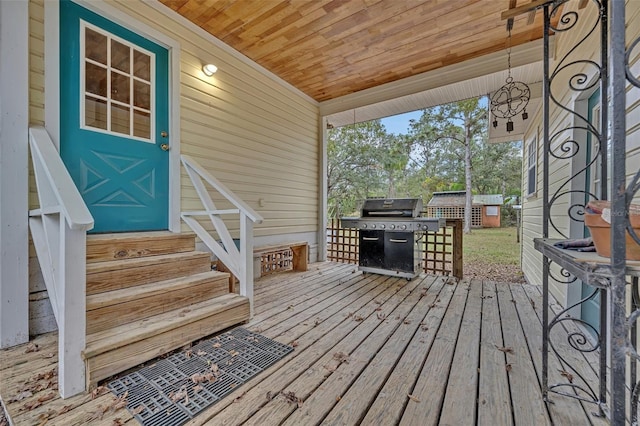 deck with a storage shed and a grill