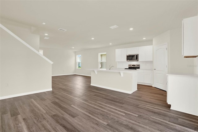 unfurnished living room featuring sink and dark hardwood / wood-style floors