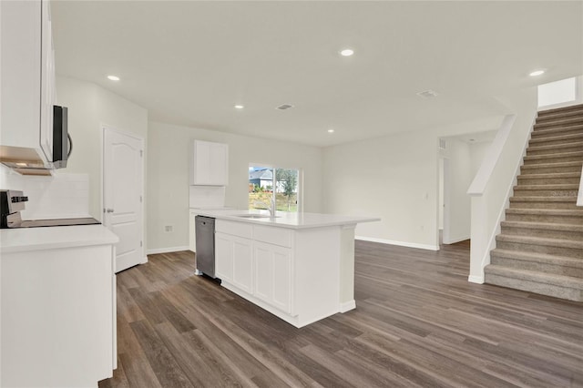 kitchen featuring white cabinetry, sink, dark hardwood / wood-style flooring, a kitchen island with sink, and stainless steel appliances