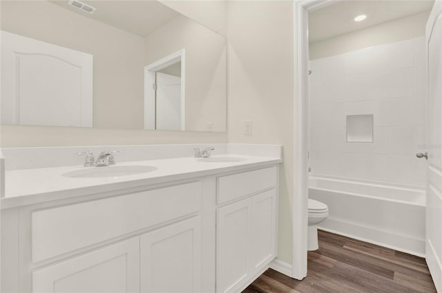 full bathroom with shower / tub combination, vanity, toilet, and hardwood / wood-style floors