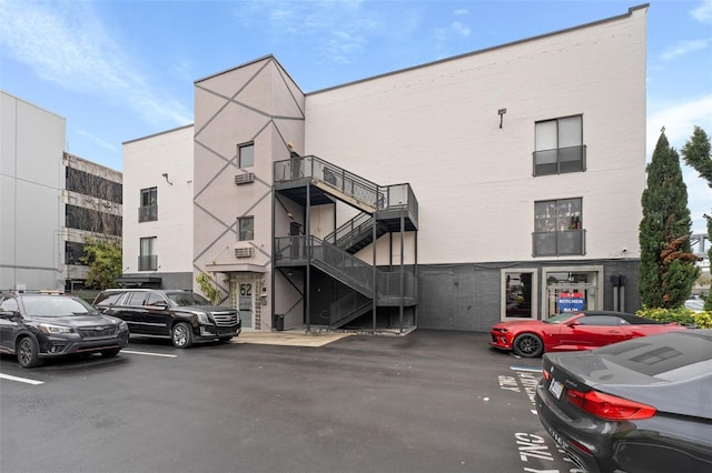 view of building exterior featuring stairs and uncovered parking