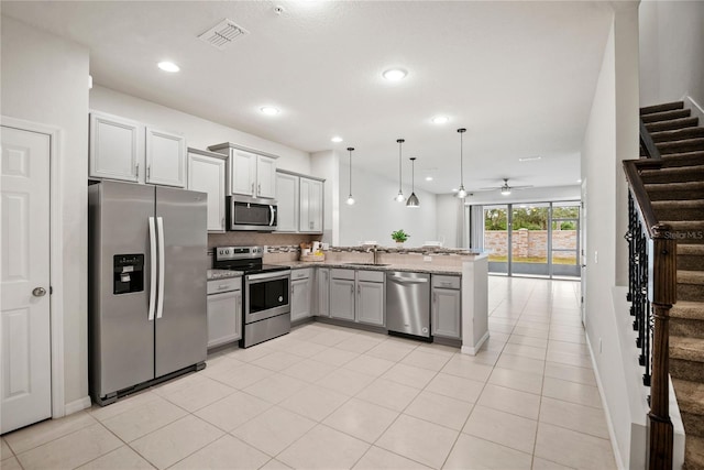 kitchen with sink, gray cabinetry, stainless steel appliances, kitchen peninsula, and hanging light fixtures