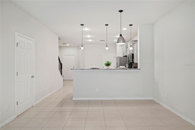 kitchen with kitchen peninsula, decorative light fixtures, light stone countertops, appliances with stainless steel finishes, and white cabinets