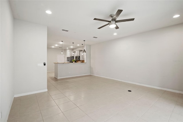 spare room with light tile patterned flooring and ceiling fan