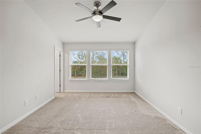 carpeted spare room featuring ceiling fan and a textured ceiling