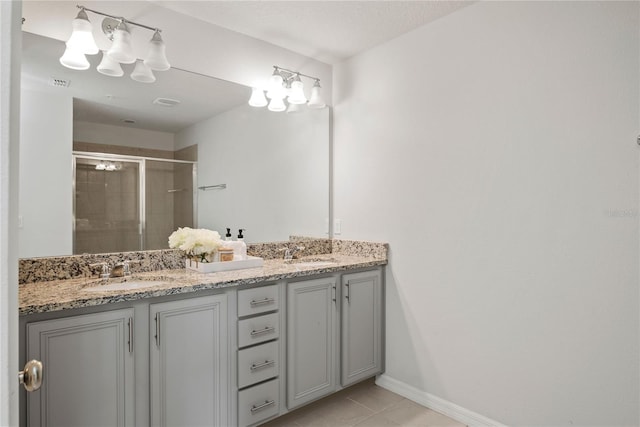 bathroom featuring tile patterned flooring, an enclosed shower, and vanity