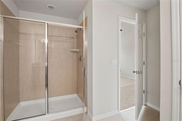 bathroom featuring tile patterned floors, a textured ceiling, and a shower with door