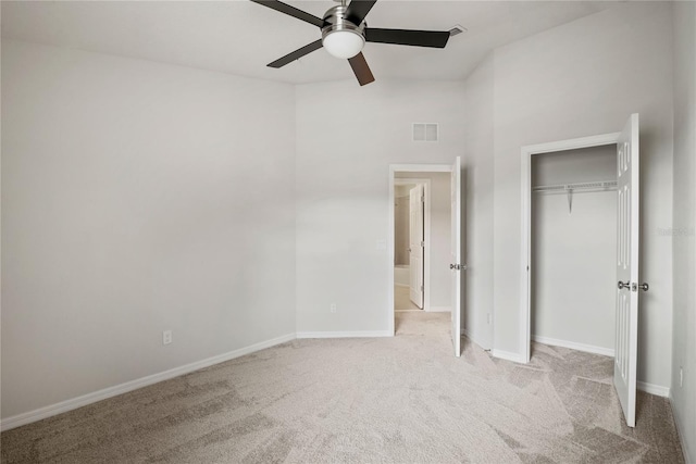 unfurnished bedroom featuring light carpet, ceiling fan, and a closet