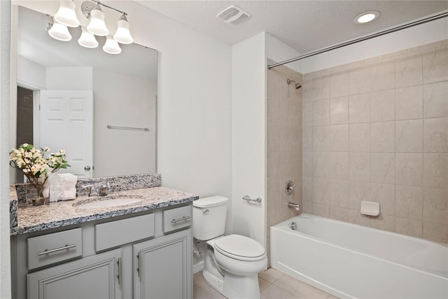 full bathroom with tile patterned flooring, toilet, a textured ceiling, vanity, and tiled shower / bath combo