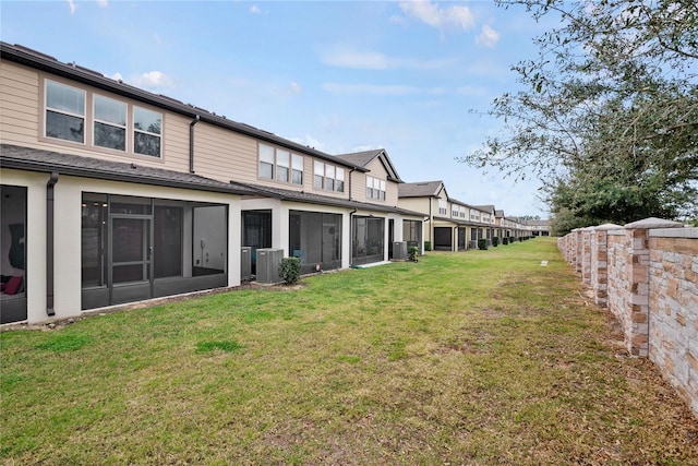 rear view of property with a yard and central AC