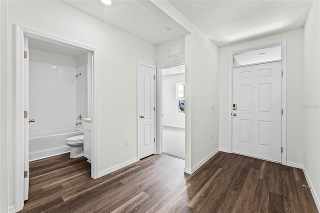 entrance foyer featuring a textured ceiling and dark hardwood / wood-style flooring