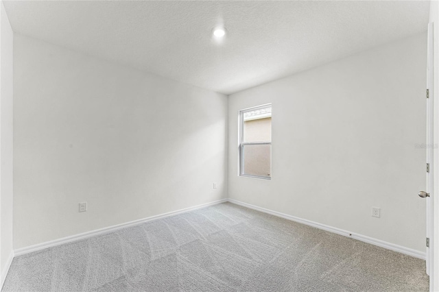 spare room with a textured ceiling and carpet