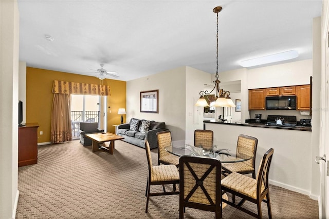 carpeted dining room featuring ceiling fan