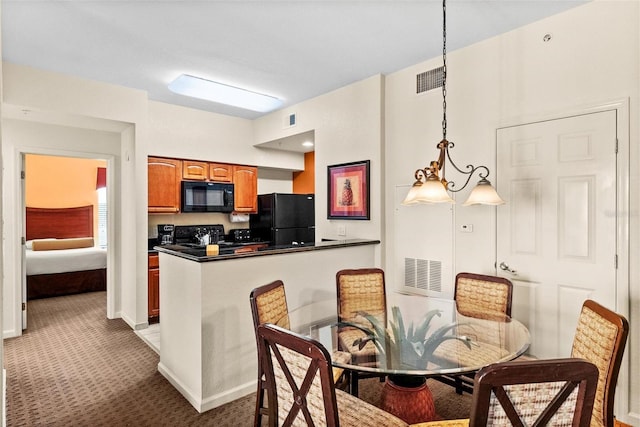 kitchen featuring kitchen peninsula, carpet, hanging light fixtures, and black appliances