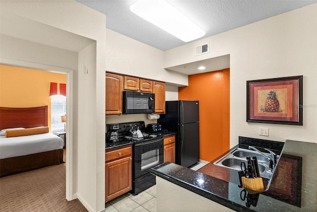 kitchen with sink, black appliances, a textured ceiling, light tile patterned flooring, and dark stone counters