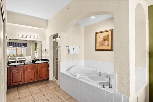 bathroom featuring plus walk in shower, vanity, and tile patterned floors