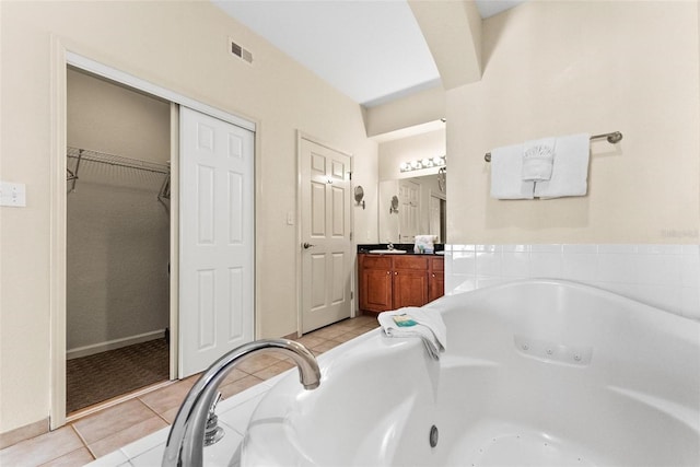 bathroom featuring a tub to relax in, tile patterned flooring, and vanity