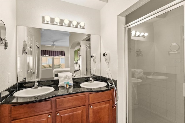 bathroom with vanity, a shower with shower door, and ceiling fan