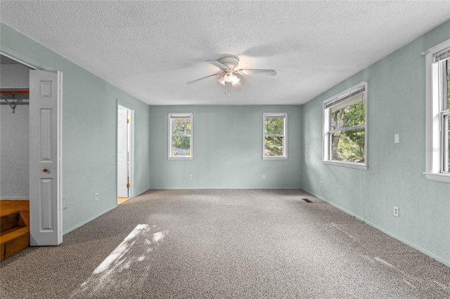 unfurnished bedroom featuring ceiling fan, carpet, and a textured ceiling