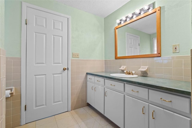 bathroom featuring tile walls, vanity, tile patterned floors, and a textured ceiling