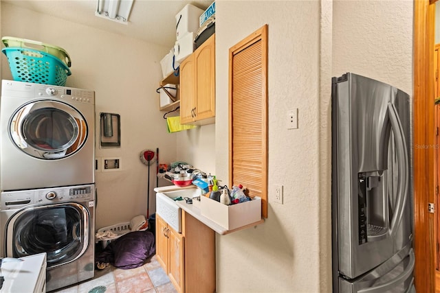 washroom with stacked washer / dryer and cabinets