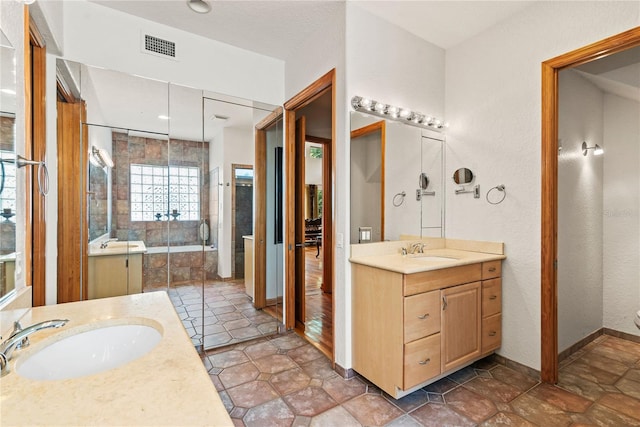 bathroom featuring vanity and tiled bath